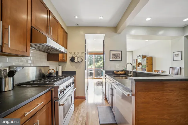 a kitchen with stainless steel appliances granite countertop a stove sink and cabinets