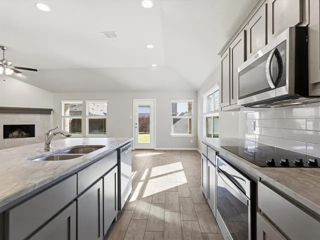 a view of a kitchen with a sink and a fireplace