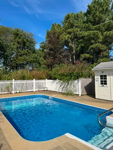 a view of a chair and table in backyard of the house