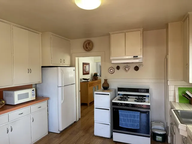 a kitchen with cabinets appliances and wooden floor