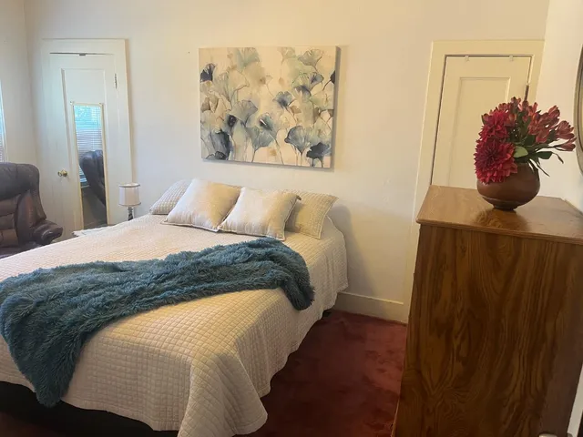 a bedroom with a bed and a potted plant