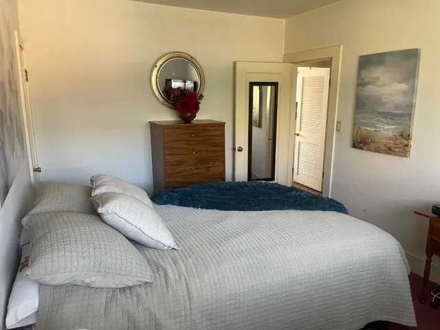 a bedroom with a bed and a painting on the wall