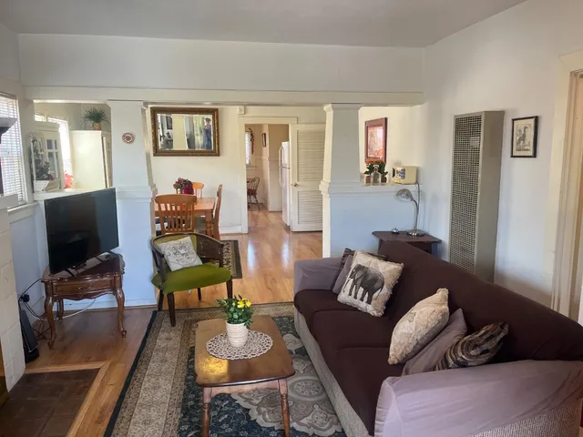 a living room with furniture and a flat screen tv with wooden floor