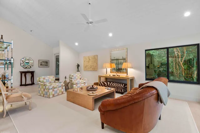 a living room with furniture large window and flat screen tv