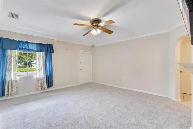 a view of a livingroom with a ceiling fan and window