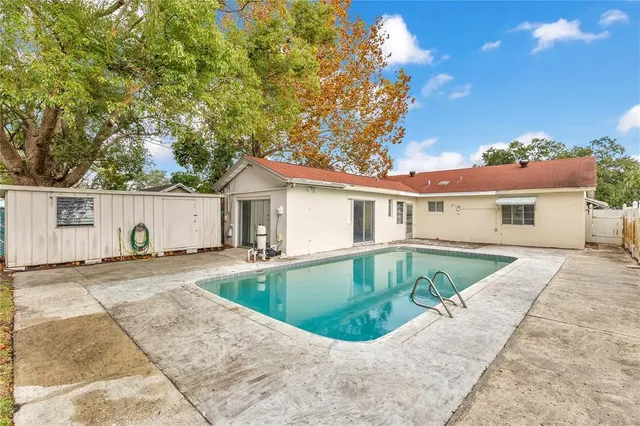a view of backyard with swimming pool and outdoor seating