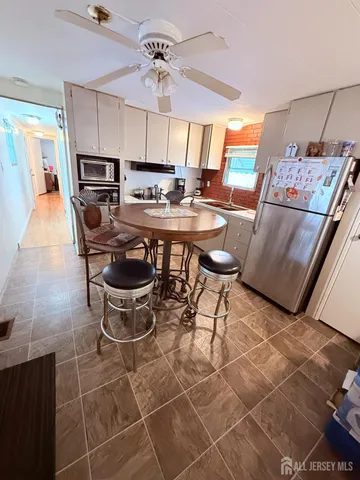 a kitchen with stainless steel appliances a table chairs and a refrigerator