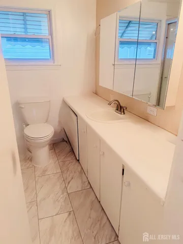 a bathroom with a toilet sink and mirror