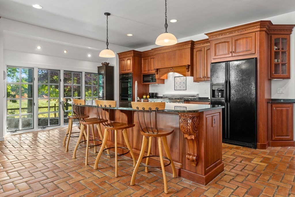 48 High Ridge Road Boxford, MA 01921 - Photo 14 of 42 a kitchen with stainless steel appliances kitchen island granite countertop a refrigerator a oven a sink with a dining table and chairs