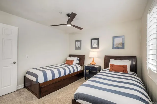 a bedroom with two beds and painting on the wall