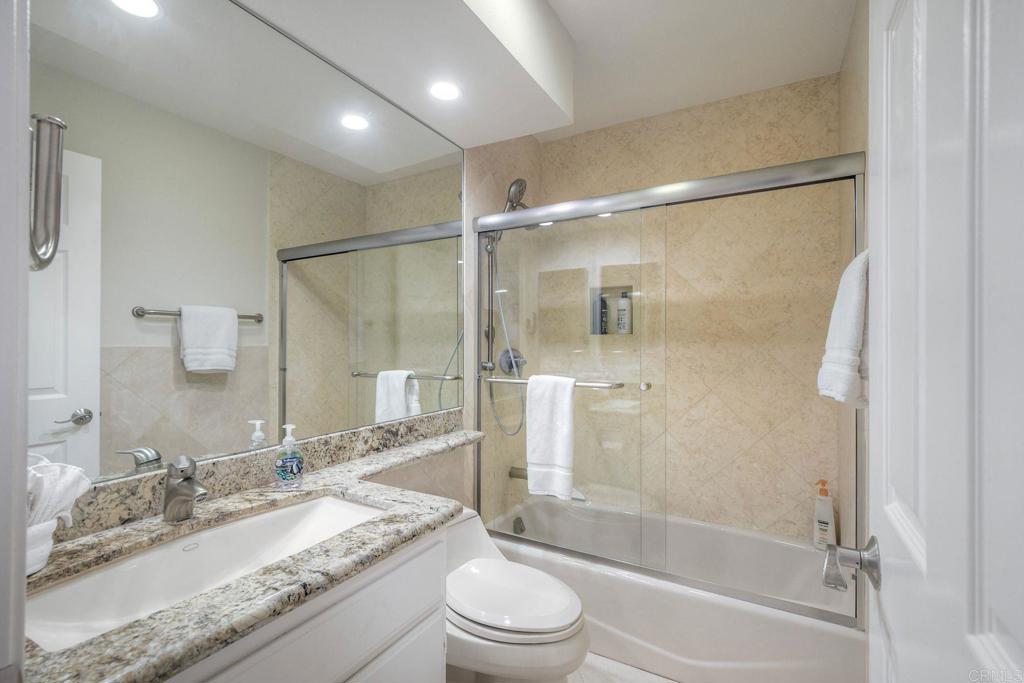 400 North Pacific Street, Unit 314 Oceanside, CA 92054 - Photo 14 of 20 a bathroom with a granite countertop sink toilet and shower