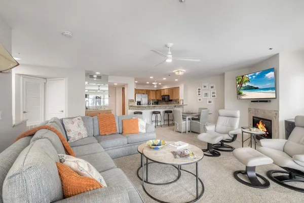 a living room with furniture kitchen view and a fireplace