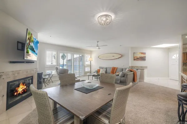 a view of a dining room with furniture a fireplace and wooden floor