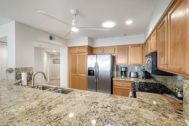 a kitchen with stainless steel appliances granite countertop a sink refrigerator and cabinets