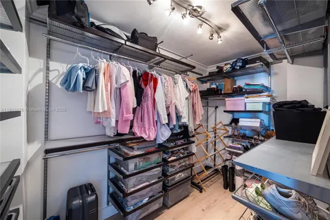 a view of walk in closet with clothes and shoes