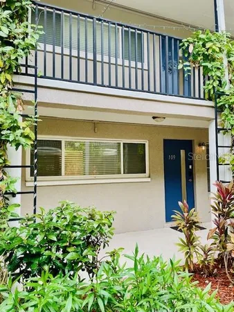 a view of a house with potted plants and a large window