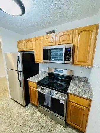a kitchen with stainless steel appliances granite countertop a stove microwave and refrigerator