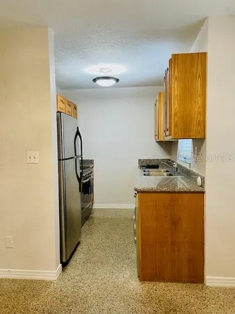 a kitchen with stainless steel appliances granite countertop a refrigerator and a stove