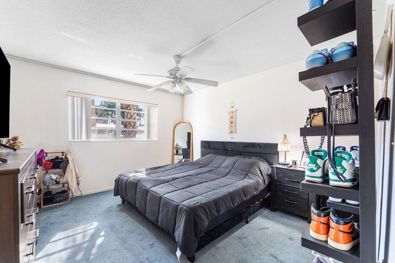 5701 Northwest 2nd Avenue Boca Raton, FL 33487 - Photo 12 of 26 a bedroom with a bed and a chandelier