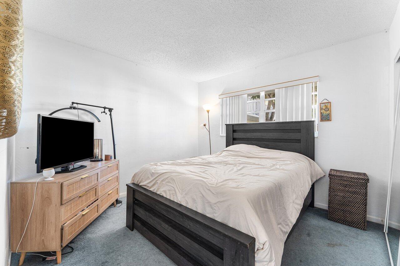 5701 Northwest 2nd Avenue Boca Raton, FL 33487 - Photo 18 of 26 a bedroom with a bed and a flat screen tv