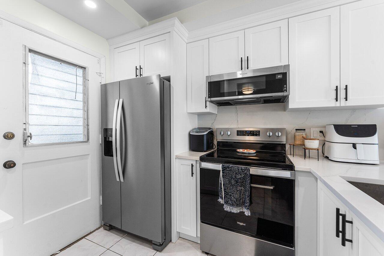 5701 Northwest 2nd Avenue Boca Raton, FL 33487 - Photo 6 of 26 a kitchen with stainless steel appliances granite countertop a refrigerator stove and sink