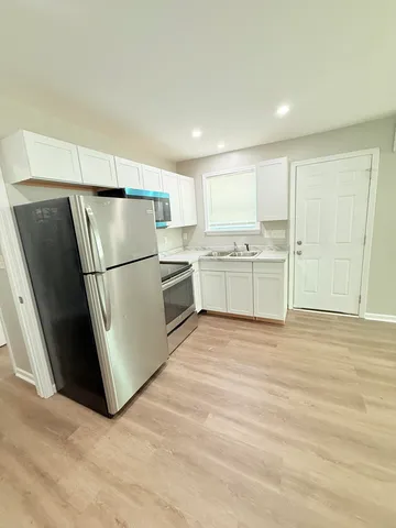 a kitchen with granite countertop a refrigerator and a sink