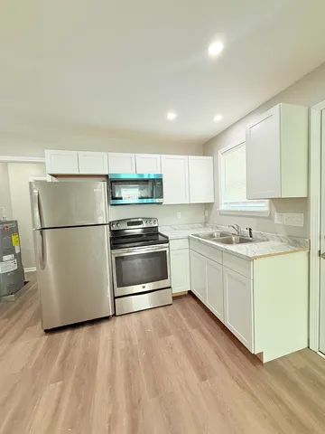 a kitchen with granite countertop white cabinets and white appliances