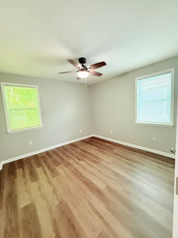 an empty room with a window and a ceiling fan