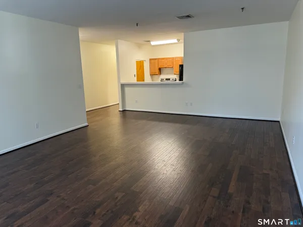 an empty room with wooden floor and a window
