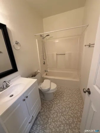 a bathroom with a granite countertop sink toilet a mirror and shower