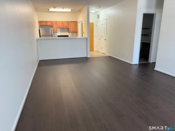 a view of a kitchen with wooden floor and a refrigerator