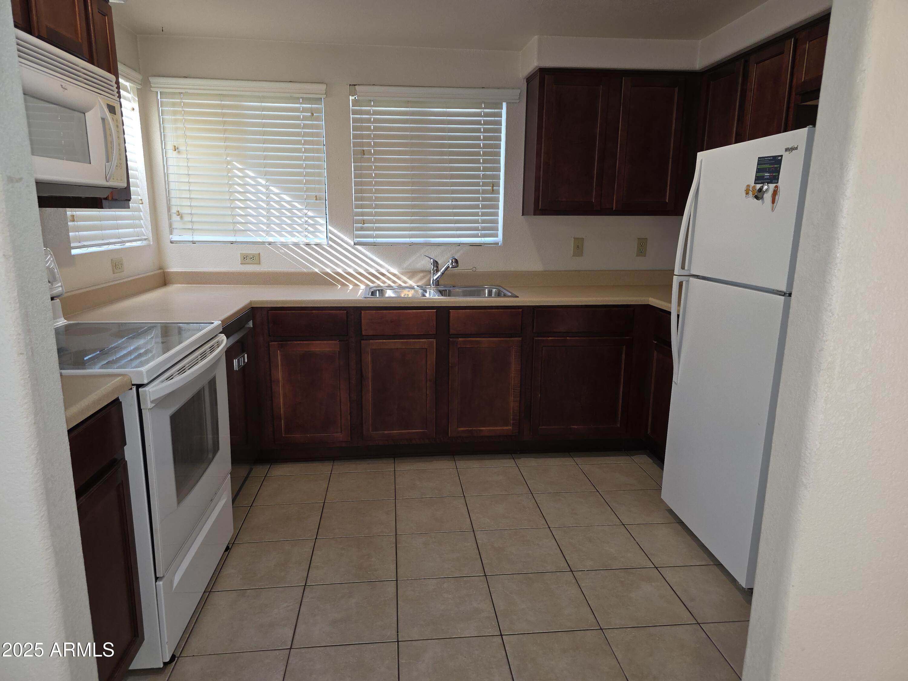 750 East Northern Avenue, Unit 1052 Phoenix, AZ 85020 - Photo 5 of 15 a kitchen with a refrigerator and a sink
