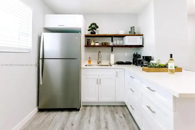 a kitchen with stainless steel appliances a refrigerator sink and cabinets