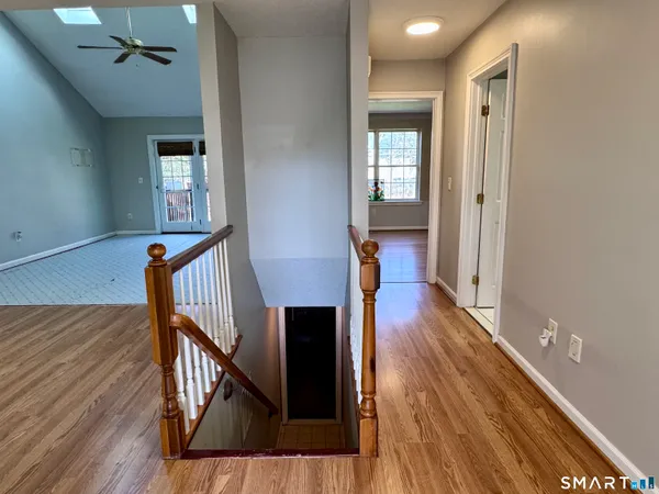 a view of a hallway with wooden floor and staircase