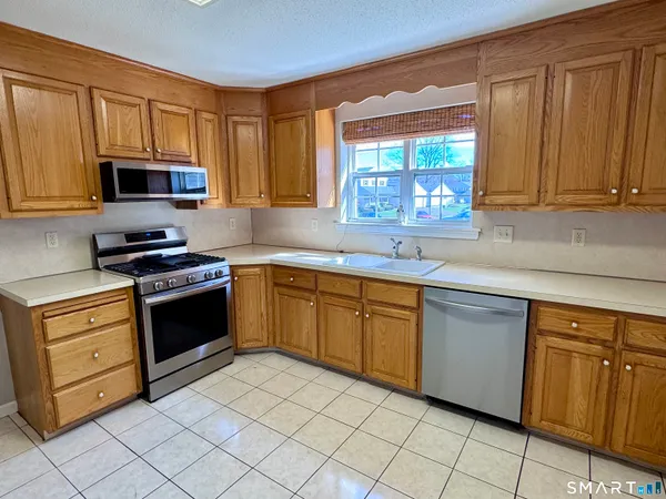 a kitchen with cabinets appliances a sink and a window