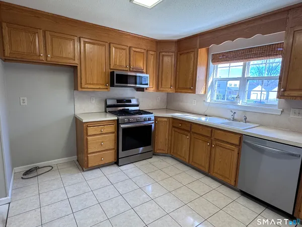 a kitchen with stainless steel appliances granite countertop a sink and dishwasher a stove top oven with white cabinets