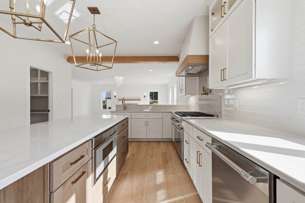 16 Couture Way Middleton, MA 01949 - Photo 7 of 36 a kitchen with a sink dishwasher stove and white cabinets with wooden floor