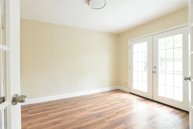 an empty room with wooden floor and window