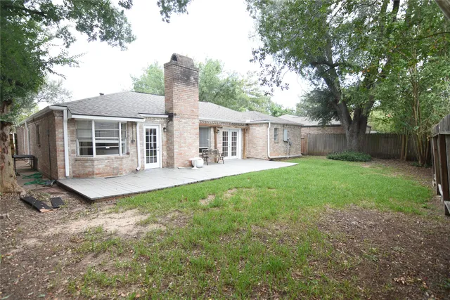 a view of a house with backyard and a tree