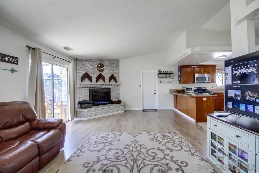 861 Peutz Valley Road Alpine, CA 91901 - Photo 11 of 42 a living room with furniture a kitchen view and a fireplace
