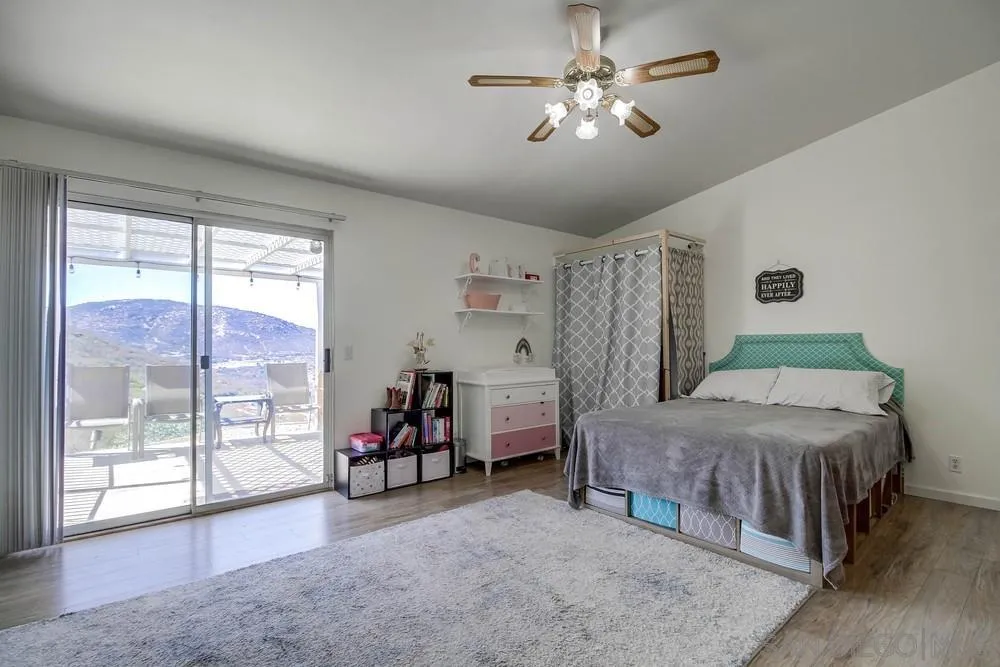 861 Peutz Valley Road Alpine, CA 91901 - Photo 14 of 42 a bedroom with a bed and a chandelier