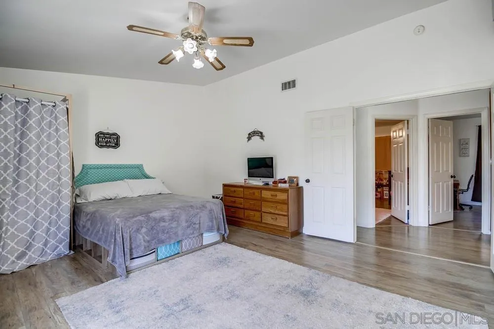 861 Peutz Valley Road Alpine, CA 91901 - Photo 16 of 42 a bedroom with a bed and a chandelier