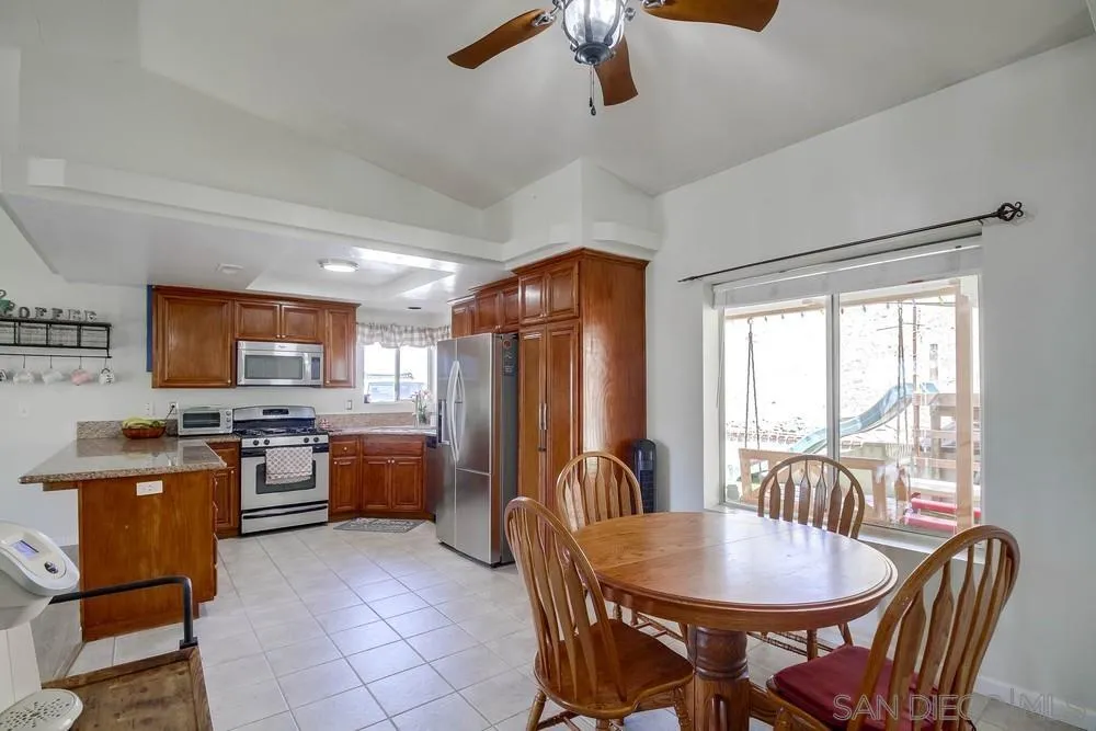 861 Peutz Valley Road Alpine, CA 91901 - Photo 2 of 42 a open kitchen with stainless steel appliances granite countertop a stove a refrigerator a kitchen island a table and chairs with a dining table and chairs