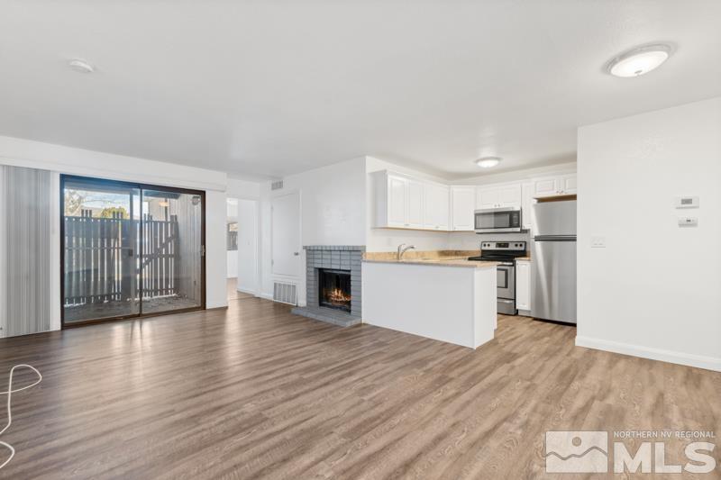 a view of kitchen with granite countertop cabinets and refrigerator