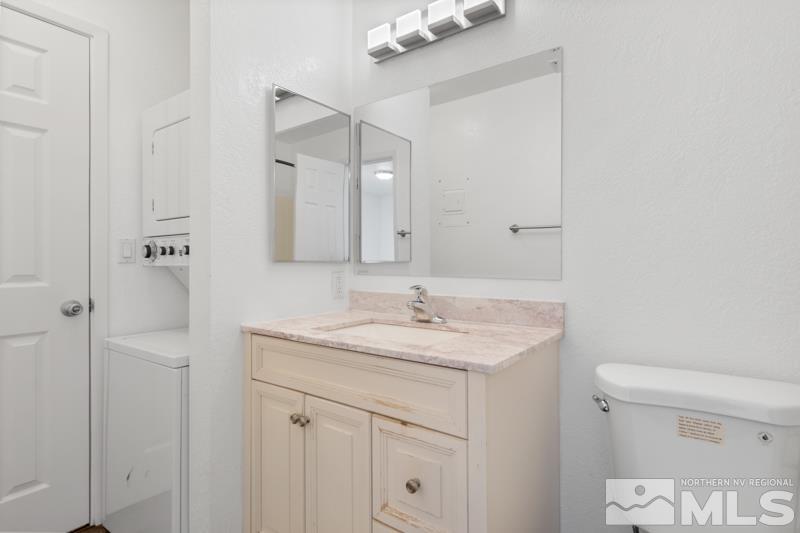 4701 Reggie Road Reno, NV 89502 - Photo 8 of 29 a bathroom with a granite countertop sink a toilet and a mirror