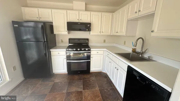 a kitchen with a sink a refrigerator and cabinets