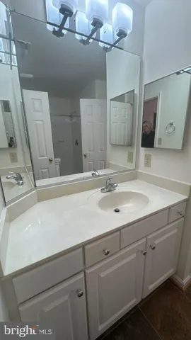 a bathroom with a sink vanity and mirror