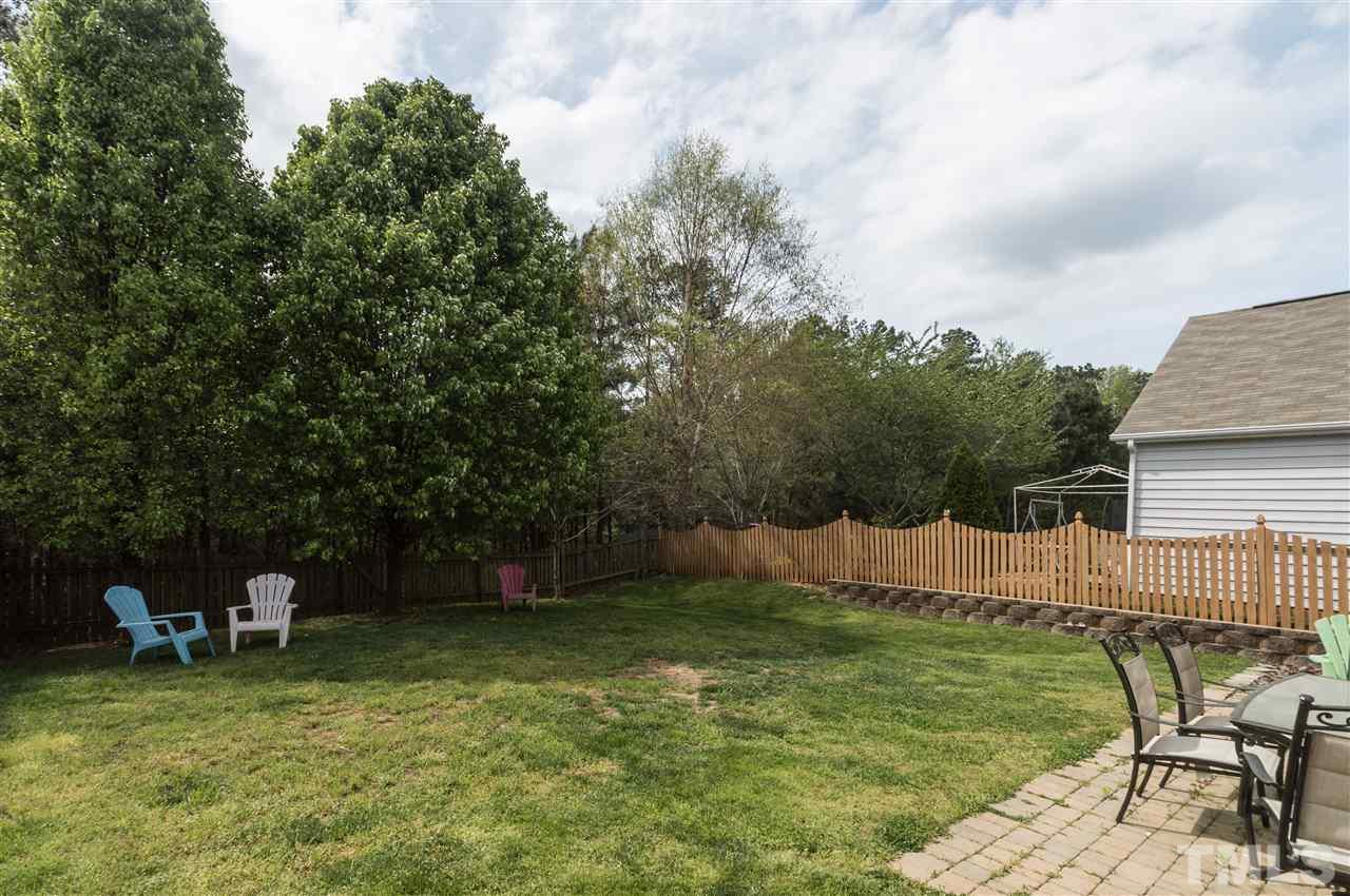 8417 Whisper Ridge Place Raleigh, NC 27613 - Photo 19 of 24 a backyard of a house with table and chairs