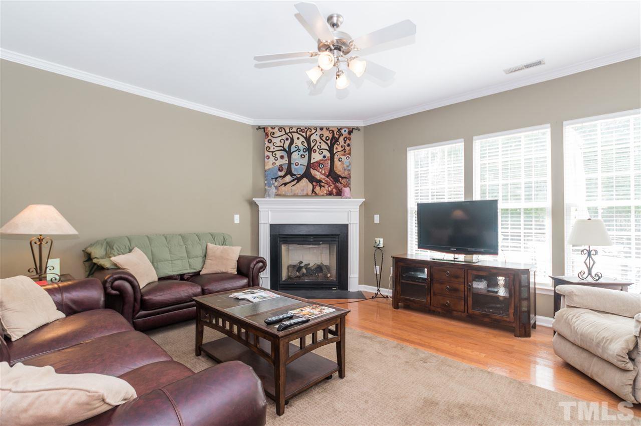 8417 Whisper Ridge Place Raleigh, NC 27613 - Photo 4 of 24 a living room with furniture a flat screen tv and a fireplace