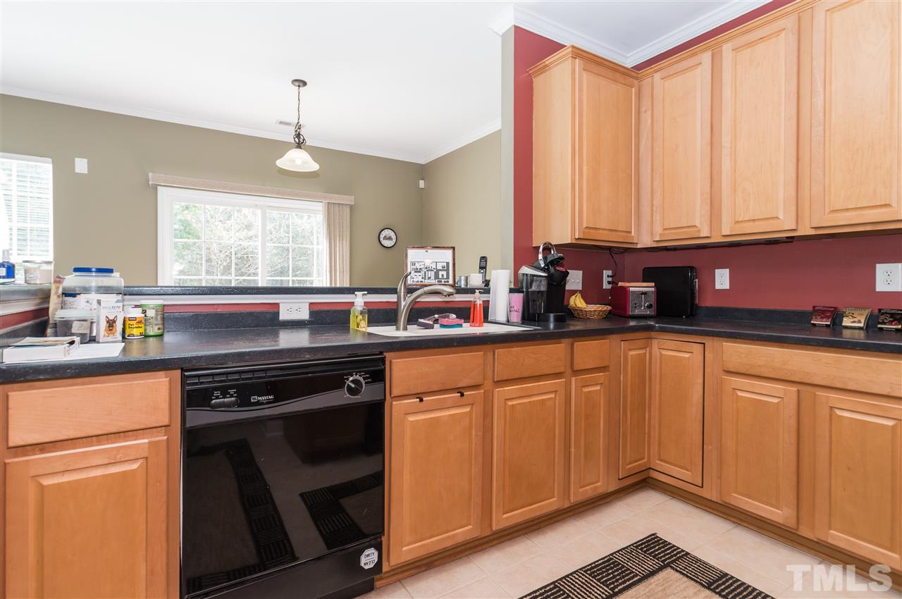 8417 Whisper Ridge Place Raleigh, NC 27613 - Photo 6 of 24 a kitchen with stainless steel appliances granite countertop a stove a sink and white cabinets